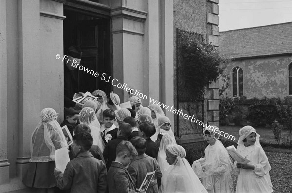 PARISH SCENE  GROUP OF CHILDREN WITH PRIEST ON DOORSTEP OF HOUSE